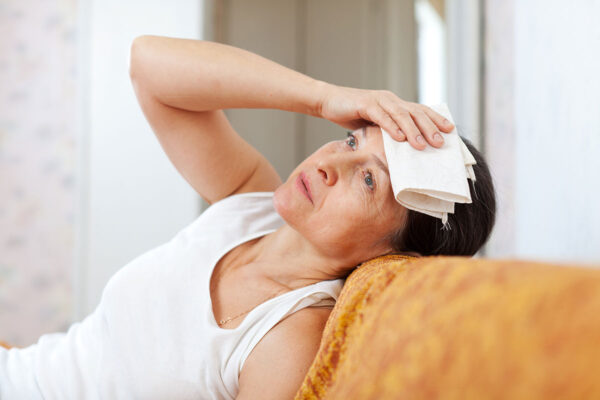Mulher com sintomas da menopausa
