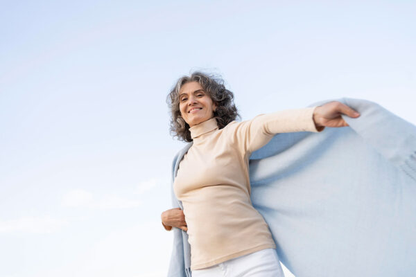Mulher madura sorridente ao ar livre, representando bem-estar durante a menopausa